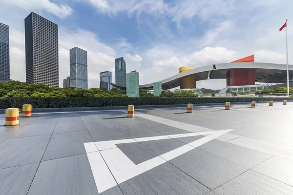 Panoramik siluet ve boş yolu, boş beton zemini olan modern iş binaları.