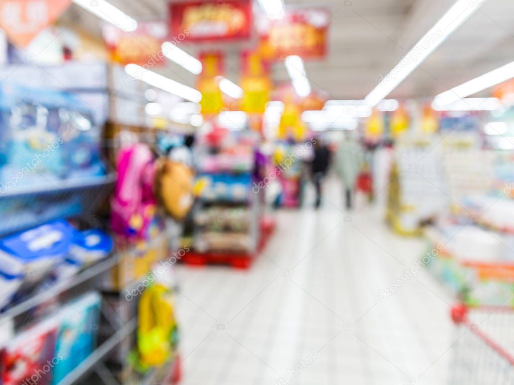 Abstract blurred supermarket aisle with colorful shelves and unrecognizable customers as background