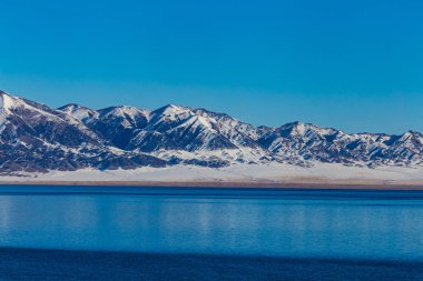  Kar dağ arka plan yılı, Çin Xinjiang, donmuş Sailimu Gölü.
