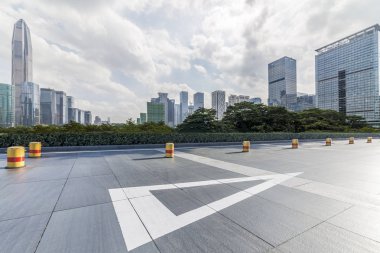 Panoramik siluet ve boş yolu, boş beton zemini olan modern iş binaları.