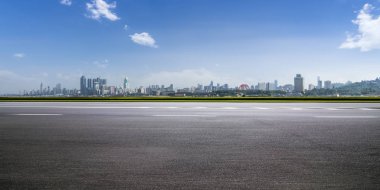 Panoramik siluet ve boş yolu, boş beton zemini olan modern iş binaları.
