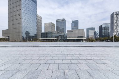 Panoramik siluet ve boş yolu, boş beton zemini olan modern iş binaları.