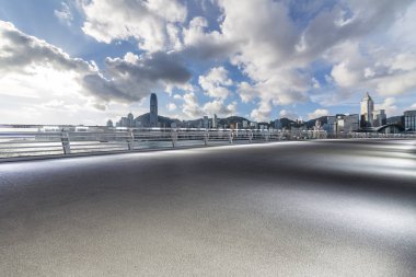 Panoramik siluet ve boş yolu, boş beton zemini olan modern iş binaları.