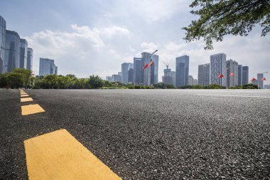 Panoramik siluet ve boş yolu, boş beton zemini olan modern iş binaları.