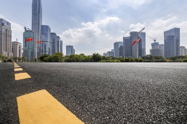 Panoramik siluet ve boş yolu, boş beton zemini olan modern iş binaları.