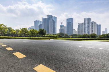 Panoramik siluet ve boş yolu, boş beton zemini olan modern iş binaları.
