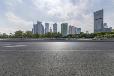 Panoramik siluet ve boş yolu, boş beton zemini olan modern iş binaları.