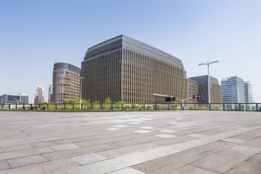 Panoramik siluet ve boş yolu, boş beton zemini olan modern iş binaları.