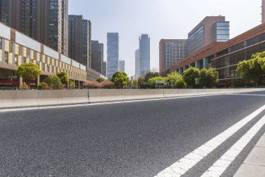 Panoramik siluet ve boş yolu, boş beton zemini olan modern iş binaları.