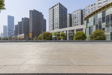 Panoramik siluet ve boş yolu, boş beton zemini olan modern iş binaları.