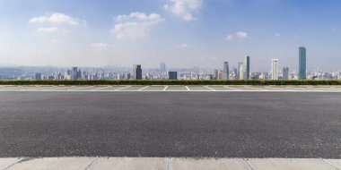 Panoramik siluet ve boş yolu, boş beton zemini olan modern iş binaları.