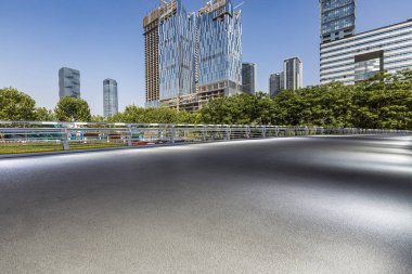 Panoramik siluet ve boş yolu, boş beton zemini olan modern iş binaları.
