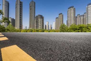 Panoramik siluet ve boş yolu, boş beton zemini olan modern iş binaları.