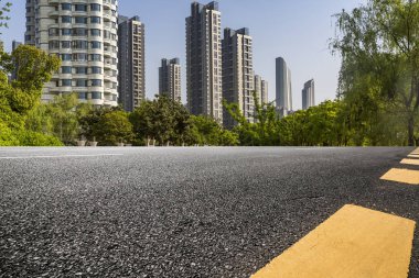 Panoramik siluet ve boş yolu, boş beton zemini olan modern iş binaları.