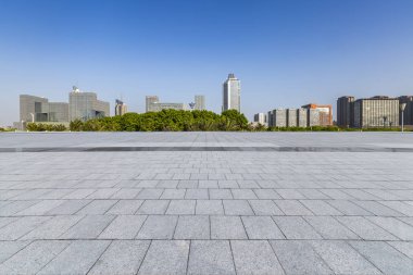 Panoramik siluet ve boş yolu, boş beton zemini olan modern iş binaları.