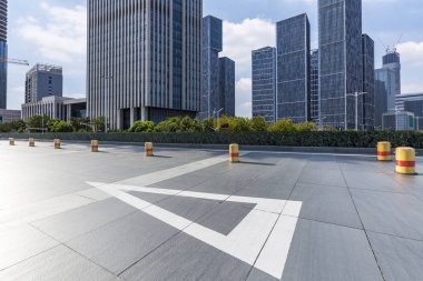 Panoramik siluet ve boş yolu, boş beton zemini olan modern iş binaları.