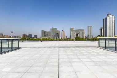 Panoramik siluet ve boş yolu, boş beton zemini olan modern iş binaları.