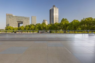 Panoramik siluet ve boş yolu, boş beton zemini olan modern iş binaları.