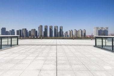 Panoramik siluet ve boş yolu, boş beton zemini olan modern iş binaları.