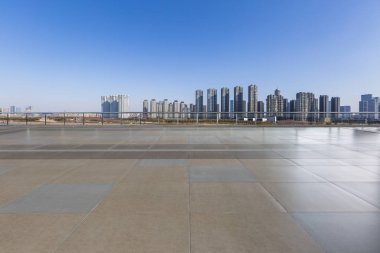 Panoramik siluet ve boş yolu, boş beton zemini olan modern iş binaları.