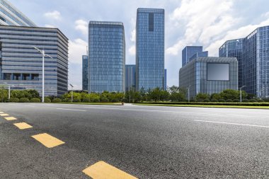 Panoramik siluet ve boş yolu, boş beton zemini olan modern iş binaları.