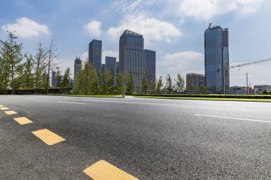 Panoramik siluet ve boş yolu, boş beton zemini olan modern iş binaları.