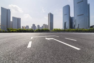 Panoramik siluet ve boş yolu, boş beton zemini olan modern iş binaları.