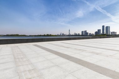 Panoramik siluet ve boş yolu, boş beton zemini olan modern iş binaları.