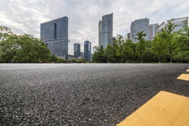 Panoramik siluet ve boş yolu, boş beton zemini olan modern iş binaları.