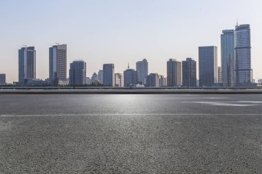 Panoramik siluet ve boş yolu, boş beton zemini olan modern iş binaları.