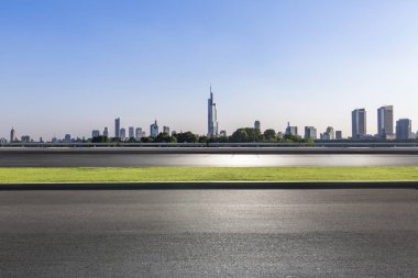 Panoramik siluet ve boş yolu, boş beton zemini olan modern iş binaları.