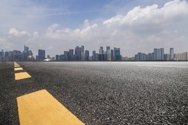Panoramik siluet ve boş yolu, boş beton zemini olan modern iş binaları.