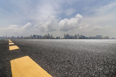 Panoramik siluet ve boş yolu, boş beton zemini olan modern iş binaları.