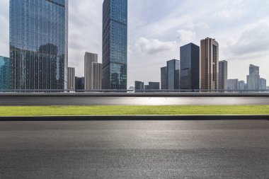 Panoramik siluet ve boş yolu, boş beton zemini olan modern iş binaları.