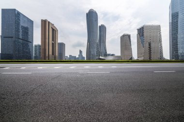 Panoramik siluet ve boş yolu, boş beton zemini olan modern iş binaları.