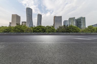 Panoramik siluet ve boş yolu, boş beton zemini olan modern iş binaları.