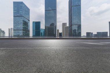 Panoramik siluet ve boş yolu, boş beton zemini olan modern iş binaları.