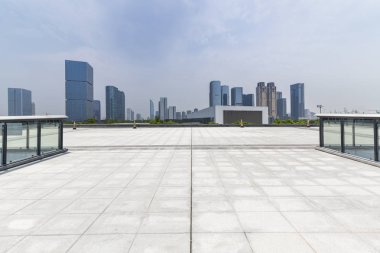 Panoramik siluet ve boş yolu, boş beton zemini olan modern iş binaları.