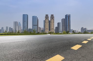 Panoramik siluet ve boş yolu, boş beton zemini olan modern iş binaları.