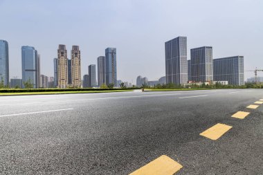 Panoramik siluet ve boş yolu, boş beton zemini olan modern iş binaları.