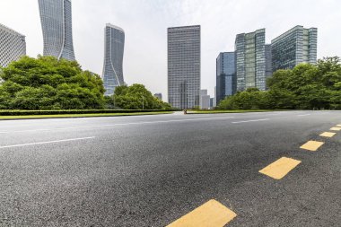 Panoramik siluet ve boş yolu, boş beton zemini olan modern iş binaları.