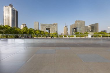 Panoramik siluet ve boş yolu, boş beton zemini olan modern iş binaları.