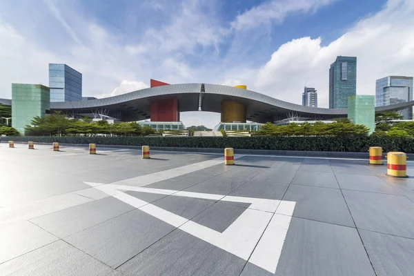 Panoramik siluet ve boş yolu, boş beton zemini olan modern iş binaları.