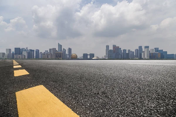 Panoramik siluet ve boş yolu, boş beton zemini olan modern iş binaları.