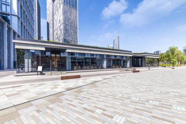 Panoramik siluet ve boş yolu, boş beton zemini olan modern iş binaları.