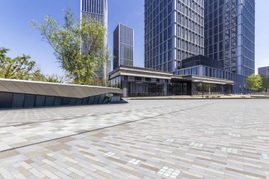 Panoramik siluet ve boş yolu, boş beton zemini olan modern iş binaları.