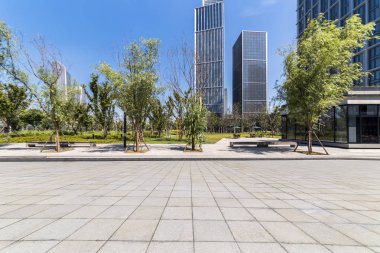Panoramik siluet ve boş yolu, boş beton zemini olan modern iş binaları.
