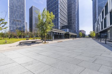 Panoramik siluet ve boş yolu, boş beton zemini olan modern iş binaları.