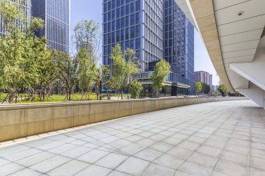 Panoramik siluet ve boş yolu, boş beton zemini olan modern iş binaları.