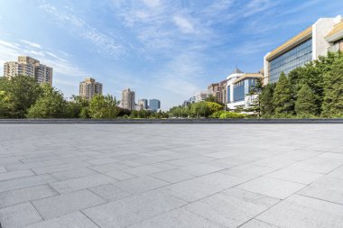 Panoramik siluet ve boş yolu, boş beton zemini olan modern iş binaları.